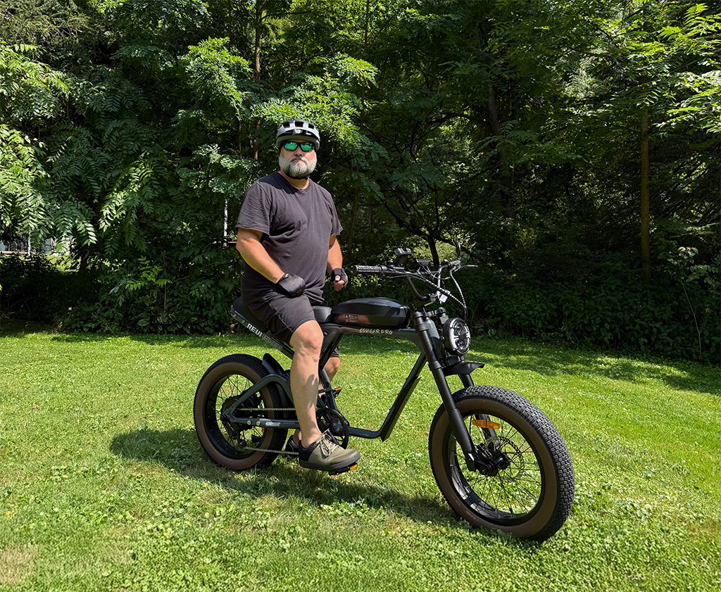 Rider resting on a grass verge on a ROOTS RIDER Cougar fat tire electric bike