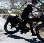 Rider in motion on a ROOTS RIDER Cheetah 2 electric bike with leather saddle bags